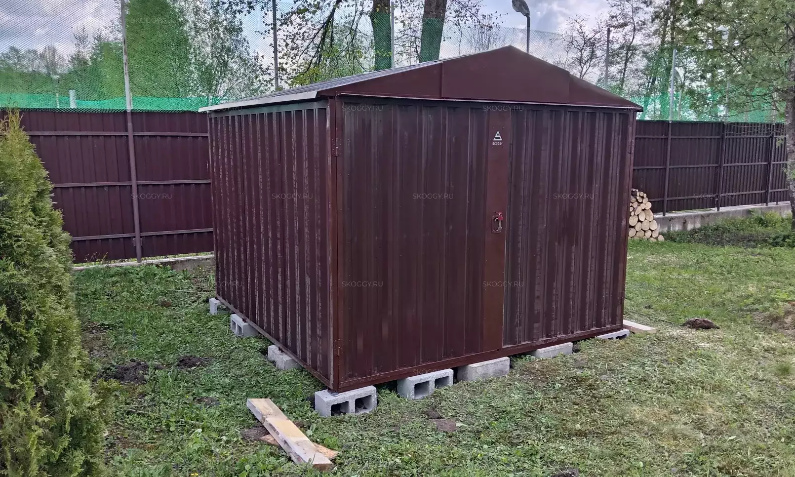 Хозблок SKOGGY коричневого цвета RAL 8017 на дачном участке
